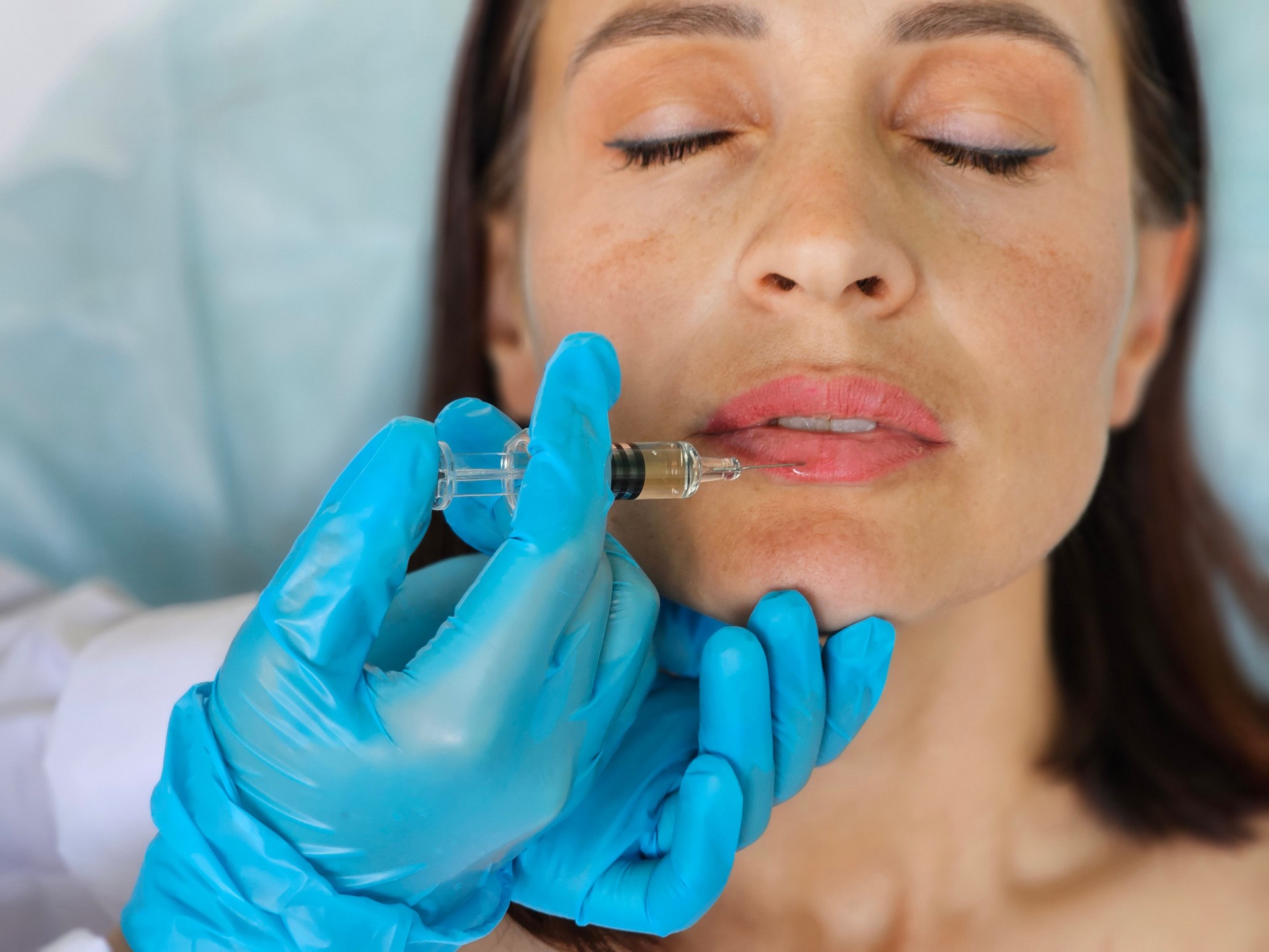 Young caucasian woman getting botox cosmetic injection in lips